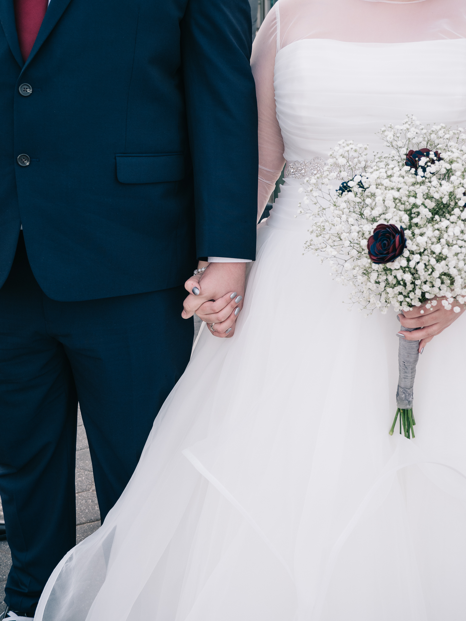bride and groom holding hands with baby breath bouquet